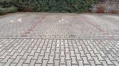 Asfaltlı park alanı, erişilebilirlik özelliklerini ve belirlenmiş alanları gösteren açık sembollerle tasarlanmıştır.