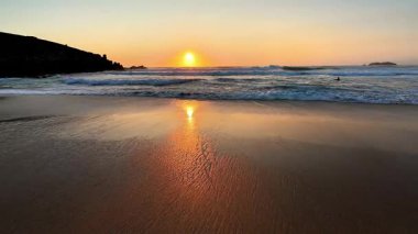 Nefes kesen bir gün batımı sakin sahili güzel bir şekilde yansıtıyor, derin bir huzur ve doğal güzelliği çağrıştırıyor.