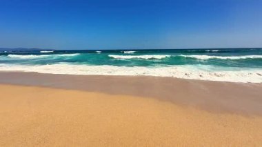 Yumuşak dalgalar ve açık bir gökyüzü olan huzurlu bir sahil sahnesi, rahatlamak ve günlük hayattan kaçmak için mükemmel.