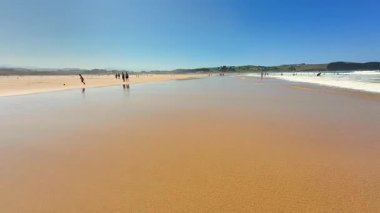 Göz kamaştırıcı bir sahil manzarası parıldayan altın kum ve parlak mavi gökyüzünün altında berrak turkuaz su
