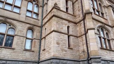 Süslü camları ve zarif mimarisi olan tarihi bir taş binanın yakın çekim görüntüsü.