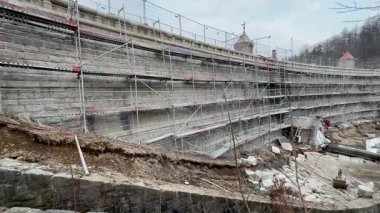 İnşaat iskelesi ve istinat duvarları için toprak çalışmalarını gösteren detaylı bir manzara