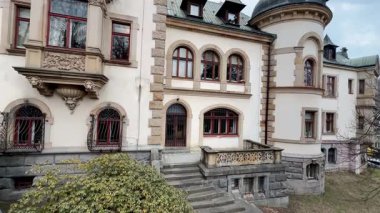 Çok iyi korunmuş bir malikane mimari detaylar sergiliyor ve büyüleyici bir girişi var.