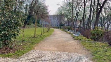 Huzurlu ve sakin bir patika huzurlu yeşil bir parkın içinden geçiyor, güzel ağaçlar ve doğa ile çevrili.