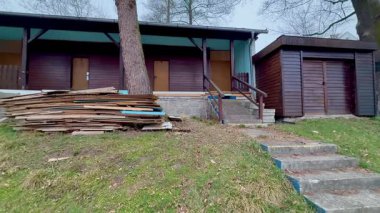 Huzurlu ve huzurlu bir kır evi manzarası. Yanında da depolama kulübesi ve düzgün istiflenmiş ahşap.