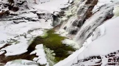 Göz kamaştırıcı bir kış sahnesi kar ve buzla çevrili görkemli çağlayan şelaleyi sergiliyor.