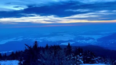 Geniş, karlı bir manzaranın nefes kesici bir görüntüsünü deneyimleyin. Canlı bir alacakaranlık altında aydınlanan.