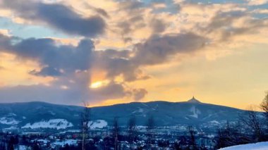 Göz kamaştırıcı bir gün batımının nefes kesici manzarası kışın zirvelerinde altın renkler sergiliyor.