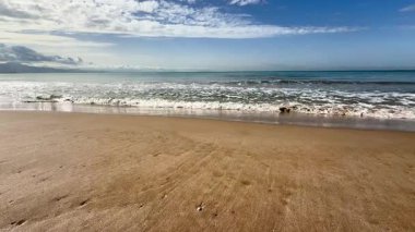 Kumlu bir sahilde hafif deniz dalgaları. Yüksek kalite 4k görüntü