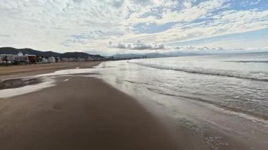 Sakin deniz kenarında kumlu sahil boyunca bir yürüyüş. Yüksek kalite 4k görüntü