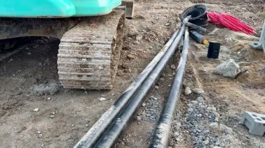 İnşaat alanı çeşitli makineler, borular ve çakıllarla dolu. Hepsi de yaklaşan bir proje için hazırlanmış.