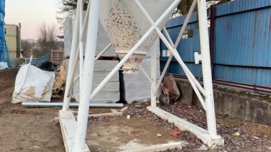 Bir inşaat sahasında etrafa saçılmış enkazlarla çevrili bir endüstriyel yapı, kentsel bozulmayı gösteriyor.