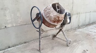 İyi kullanılmış bir beton karıştırıcı şantiyede gururla durur. Dayanıklılık ve zamanın nasıl geçtiğini gösterir.