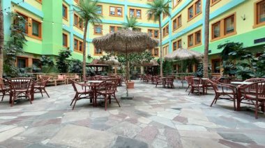 Canlı bir iç avlu, yemyeşil bitkiler ve rahat koltuklar, rahatlama ve rahatlama aktiviteleri için mükemmel.