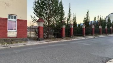 Keyifli bir şekilde geziniyor, çarpıcı çitleri ve yemyeşil bahçesiyle çarpıcı bir dış görünüşü olan klasik binaları keşfediyor.