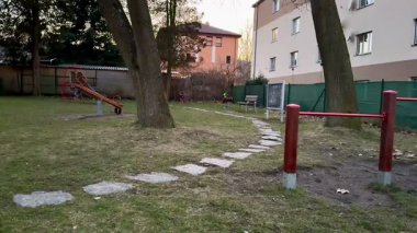 Sakin ve sakin bir oyun alanı sahnesi güzel bir patika, uzun ağaçlar ve hoş, büyüleyici bir günbatımı ortamı gösterir.