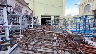 Endüstriyel bir alanda titizlikle depolanmış çeşitli metal yapı ve iskeletlerin kapsamlı bir koleksiyonu.
