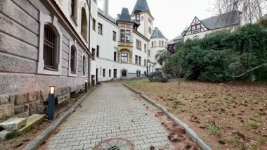 Çevresindeki sakin doğayla kucaklaşan zarif, tarihi bir binanın yanında pitoresk bir yürüyüş yolu.