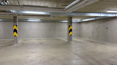 Tavan altyapısı ve boru sistemlerini gösteren bir yeraltı otoparkının kapsamlı ve ayrıntılı bir görüntüsü.