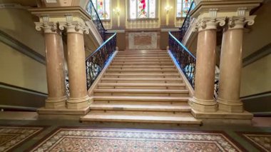 Muhteşem mimari detayların yanı sıra güzel vitraylı pencereleri gösteren büyük bir merdiven var.