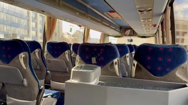 Konforlu, rahat koltuklar ve geniş pencereli çağdaş bir otobüs içi manzarası