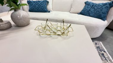 Zarif bir sehpa düzenleme dekoratif eşyalar sergileniyor, rahat, davetkar bir kanepeyle çevrili.