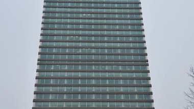 Bu, eşsiz tasarım elementleriyle birlikte çarpıcı bir cam cephe sergileyen gösterişli, modern bir bina.