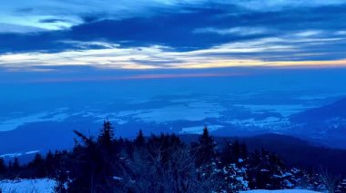 Geniş, karlı bir manzaranın nefes kesici bir görüntüsünü deneyimleyin. Canlı bir alacakaranlık altında aydınlanan.