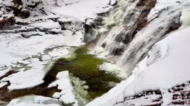 Göz kamaştırıcı bir kış sahnesi kar ve buzla çevrili görkemli çağlayan şelaleyi sergiliyor.