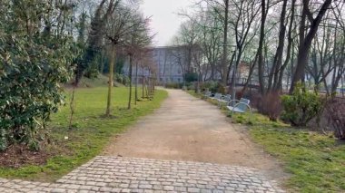 Huzurlu ve sakin bir patika huzurlu yeşil bir parkın içinden geçiyor, güzel ağaçlar ve doğa ile çevrili.