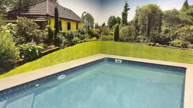 Huzurlu ve dingin bir havuz manzarası. Canlı bir bahçe ve yakınlarda büyüleyici bir ev.