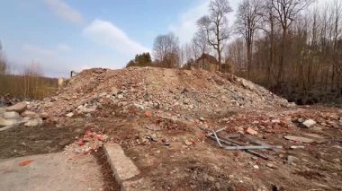 Kentsel yıkım sonucu önemli bir moloz yığını ve enkaz şimdi çıplak ağaçlarla çevrili.