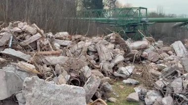 Harabelerin ve metal kalıntılarının ihmal edilmiş kentsel alana saçıldığı kaotik bir manzara.