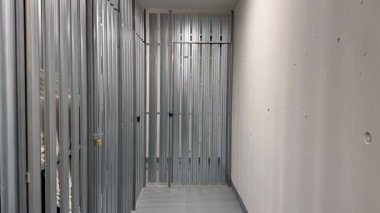 Temiz ve ferah bir koridor, metal çerçeve sergileniyor. Bu da devam eden inşaat faaliyetlerinin bir göstergesi.