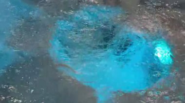 Güzel mavi ışığın yanında dinamik su hareketlerini de içeren büyüleyici ve çarpıcı bir sualtı görüntüsü.