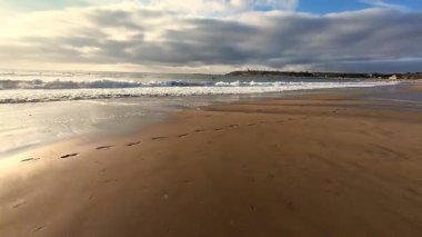Yumuşak dalgaların ve kumdaki ayak seslerinin yer aldığı sakin bir sahil sahnesi, rahatlama temaları için mükemmel..