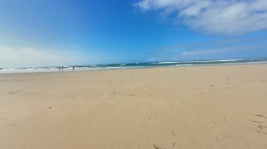 Yumuşak altın kumların ve parlak mavi gökyüzünün olduğu sakin bir sahil güneşli bir günde rahatlamak için mükemmeldir.