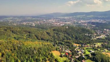 Alttaki yemyeşil manzarayı ve şehri görüntülemek, doğa ve kentsel temalar için idealdir..