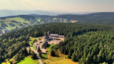 Çarpıcı bir manzara bulutlu bir gökyüzünün altındaki doğal güzellikleri gösteren yuvarlanan tepeleri ve vadileri vurguluyor.