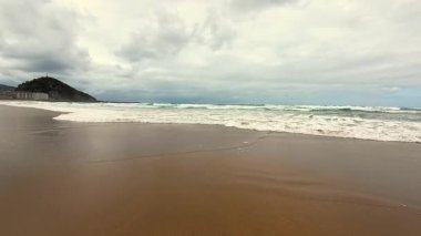 Sakin ve sakin bir sahil. Yumuşak, yumuşak dalgalar ve bulutlu bir gökyüzü. Rahatlamak ve huzurlu bir kaçış için mükemmel.