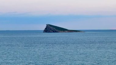 Güzel alacakaranlık saatinde sakin ve sakin okyanus sularıyla çevrili kendine özgü bir adanın çarpıcı manzarası.