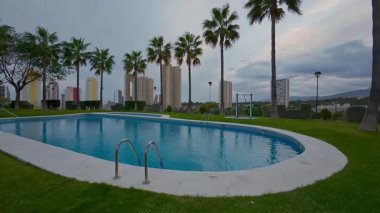 Palmiye ağaçlarıyla çevrili sakin bir havuz ve alacakaranlıkta çarpıcı bir siluet, nihai rahatlama için mükemmel.