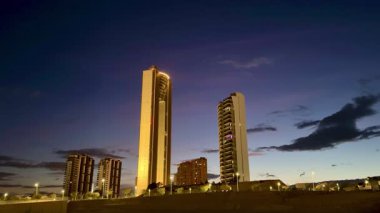 Nefes kesen alacakaranlık gökyüzüne karşı parlayan muhteşem bir şehir silueti sergileniyor.