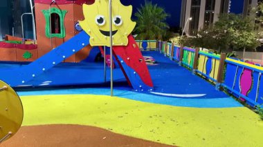 Renkli oyun yapıları ve çocuklar için güvenli yumuşak döşemelerle dolu canlı bir oyun alanı keşfedin..