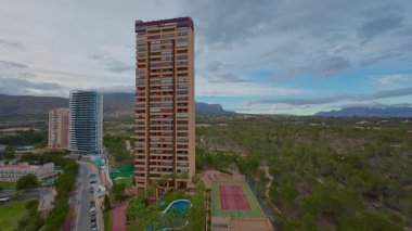 Çevresi manzara ve doğa ile çevrili, kentsel mülk görselleri için mükemmel yüksek bir binanın çarpıcı hava görüntüsü..