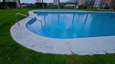 Güzel havuz alanı yemyeşil çimenler ve yüksek binalarla çevrili. Bu da onu rahatlama ve rahatlama için mükemmel yapıyor.