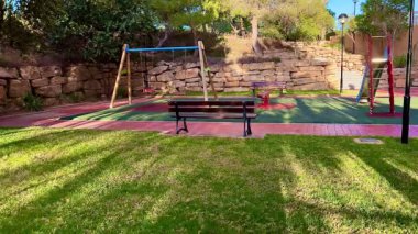 Huzurlu ve huzurlu bir oyun alanı. Huzurlu, huzurlu bir ortamda salıncaklar, banklar ve güzel yeşillikler.