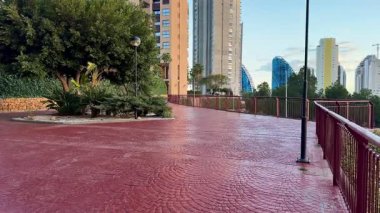 Çevresi yeşillik ve çağdaş binalarla çevrili manzaralı bir şehir geçidi, açık hava eğlencesi için mükemmel..