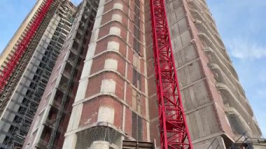 İnşaat halindeki, yapısal tasarım ve vinçlerin sergilendiği modern bir gökdelenden çarpıcı bir manzara..