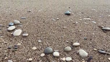 İnanılmaz güzel kumlu bir sahilde çakıl taşları ve nazik dalgalarla çevrili rahatlatıcı ve huzurlu anlar.